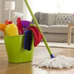 Kompleksowe sprzątanie - Jasny pokój po sprzątaniu: mop, wiadro z detergentami, odkurzone meble. Czysta podłoga z parkietu odbija światło, tworząc wrażenie świeżości.