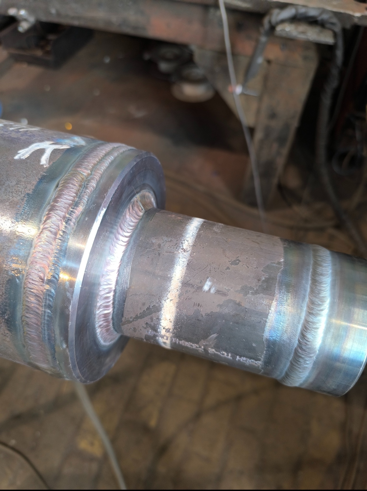 Precyzyjne łączenie rur metalowych z widocznymi śladami spawania, ukazujące estetyczne i trwałe spoiny. Detal z warsztatu.