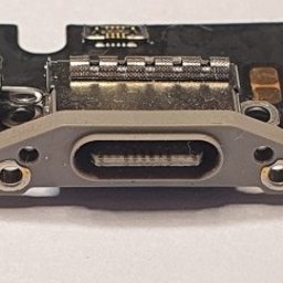 Alex Crisard - Zbliżenie na port USB-C na płycie urządzenia elektronicznego. Widoczne ślady lutowania i elementy elektroniczne. Detaliczna prezentacja naprawionego gniazda.