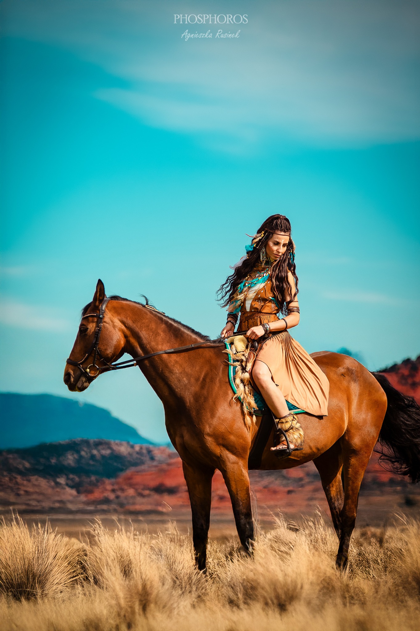 Kobieta w etnicznym stroju na koniu, w plenerze. Sesja zdjęciowa w stylu indiańskim, z elementami biżuterii i stroju nawiązującymi do kultury rdzennych Amerykanów.