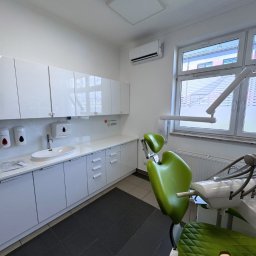 GALTO Bartosz Gałkowski - Jasne wnętrze gabinetu dentystycznego z klimatyzacją podsufitową, zielonym fotelem dentystycznym i białymi szafkami wzdłuż ściany. Widoczny napis 'EFEKT KOŃCOWY'.