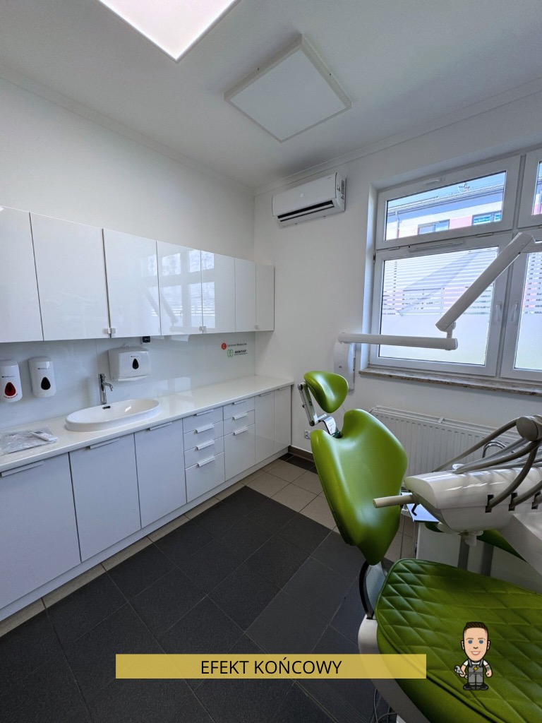 Jasne wnętrze gabinetu dentystycznego z klimatyzacją podsufitową, zielonym fotelem dentystycznym i białymi szafkami wzdłuż ściany. Widoczny napis 'EFEKT KOŃCOWY'.