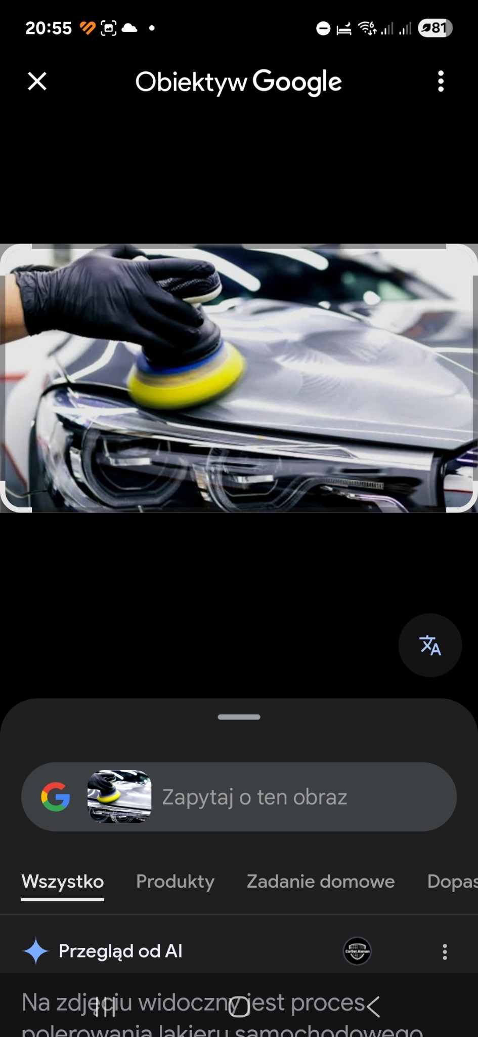 Polerowanie lakieru samochodu: dłoń w czarnej rękawicy prowadzi polerkę po masce auta, reflektor widoczny w tle. Detailing samochodowy w zbliżeniu.