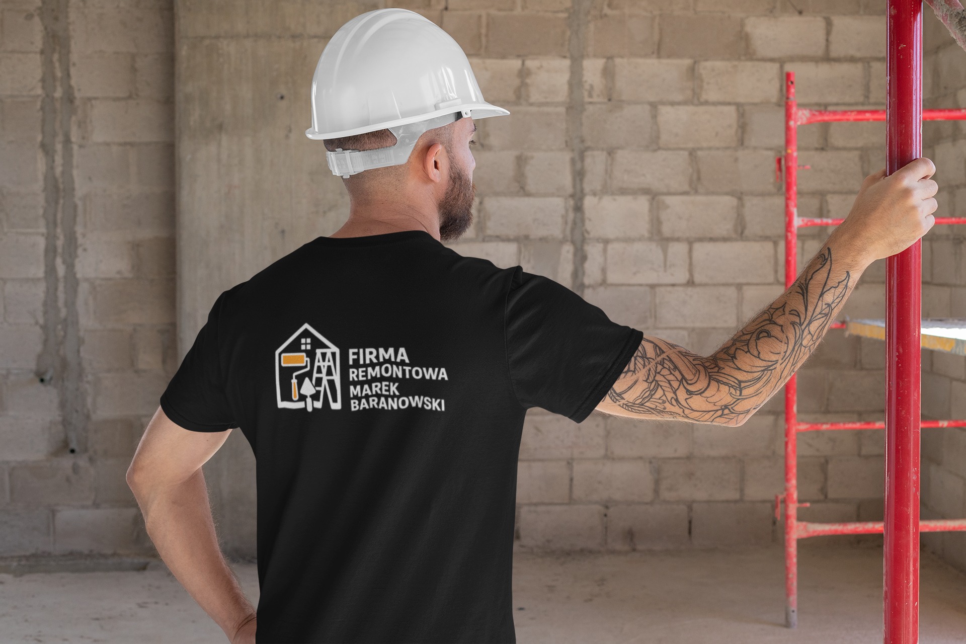 Mężczyzna w kasku i koszulce z logo firmy remontowej na budowie, trzymający się czerwonego rusztowania. Widok z tyłu, tatuaż na ramieniu.