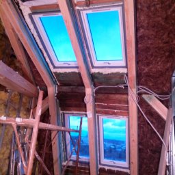 MAR-DOM Usługi remontowo-budowlane - Adaptacja poddasza: montaż okien dachowych z drewnianą konstrukcją, ocieplenie wełną mineralną, widoczne rusztowania. Prace wykończeniowe w toku.