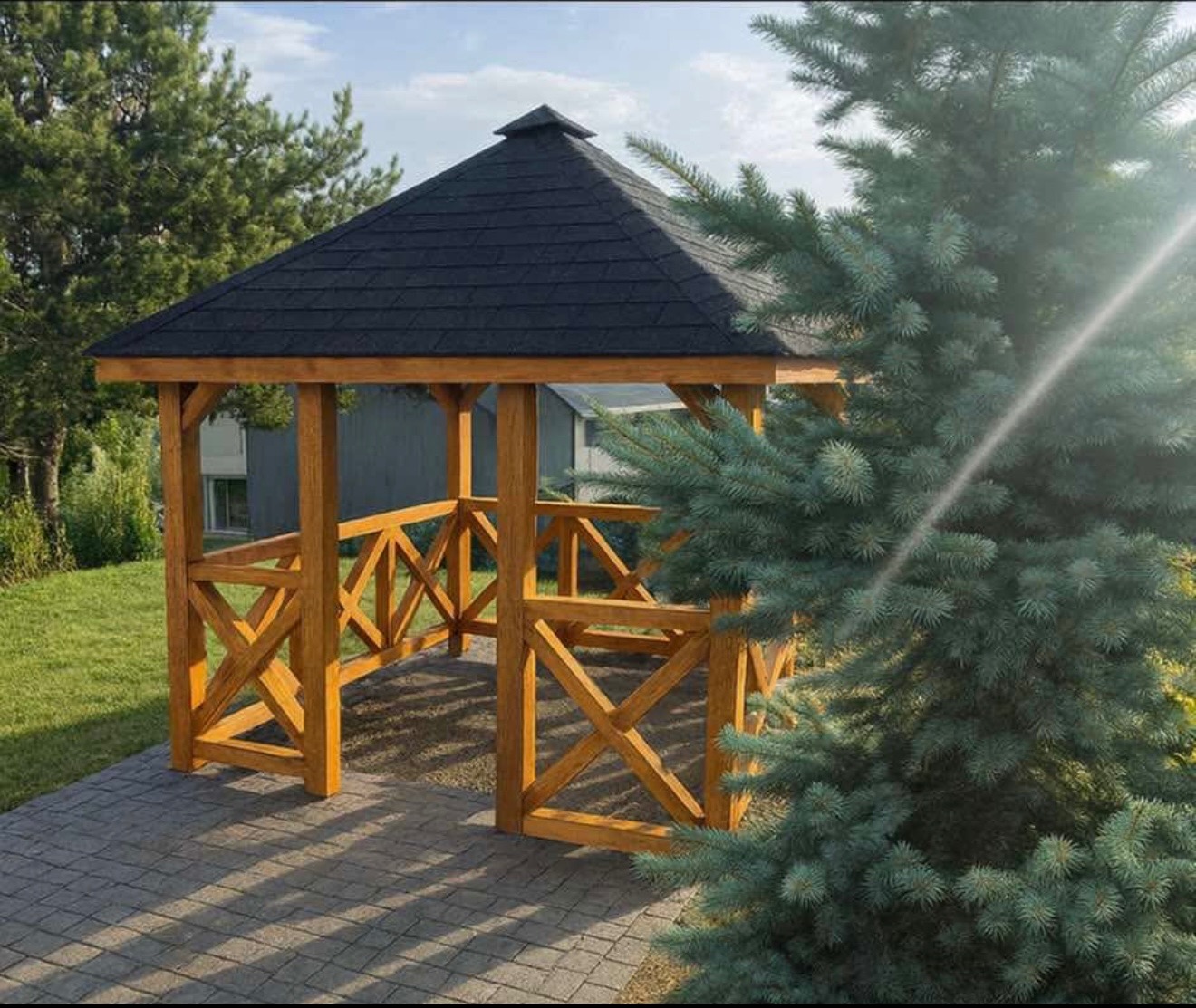 Drewniana altana ogrodowa z czarnym dachem, widoczna z perspektywy ścieżki. Konstrukcja z krzyżowymi belkami, obok iglaste drzewo, w tle trawnik i budynek.