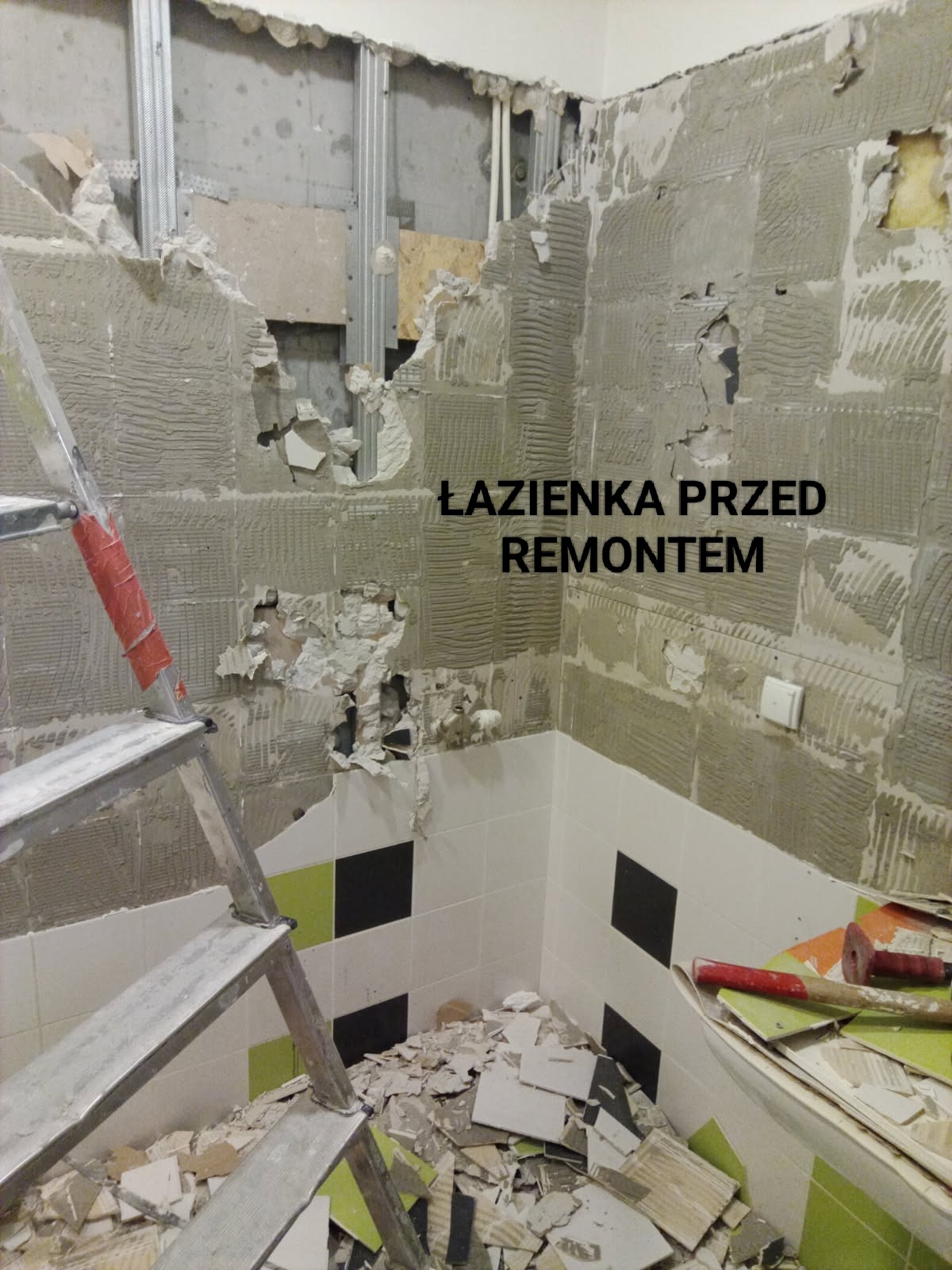 Łazienka w trakcie demontażu płytek, widoczne fragmenty ścian z resztkami kleju, drabina i gruz. Przygotowanie do remontu z widocznymi elementami konstrukcyjnymi.