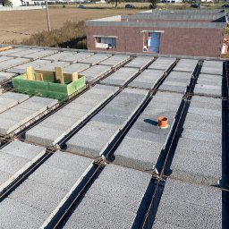 BART-BUD Bartłomiej Kujawa - Wieniec stropowy z szalunkiem i zbrojeniem na budowie domu jednorodzinnego. Widoczne bloczki szalunkowe i elementy instalacji. W tle budynek w stanie surowym otwartym.