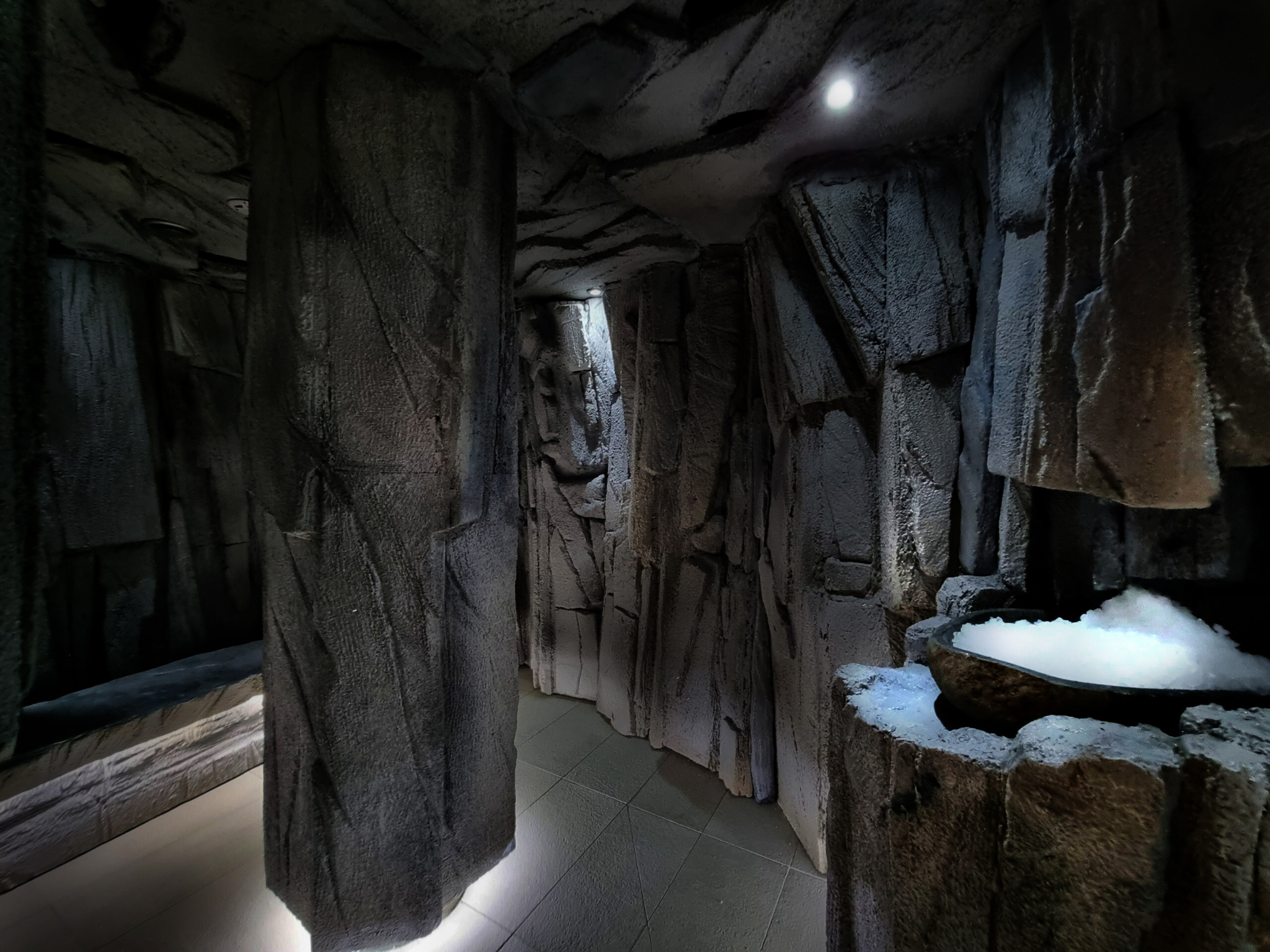 Grota solna z podświetlaną tężnią solankową i imitacją skalnych ścian. Wnętrze oświetlone punktowo, tworzące intymny klimat.