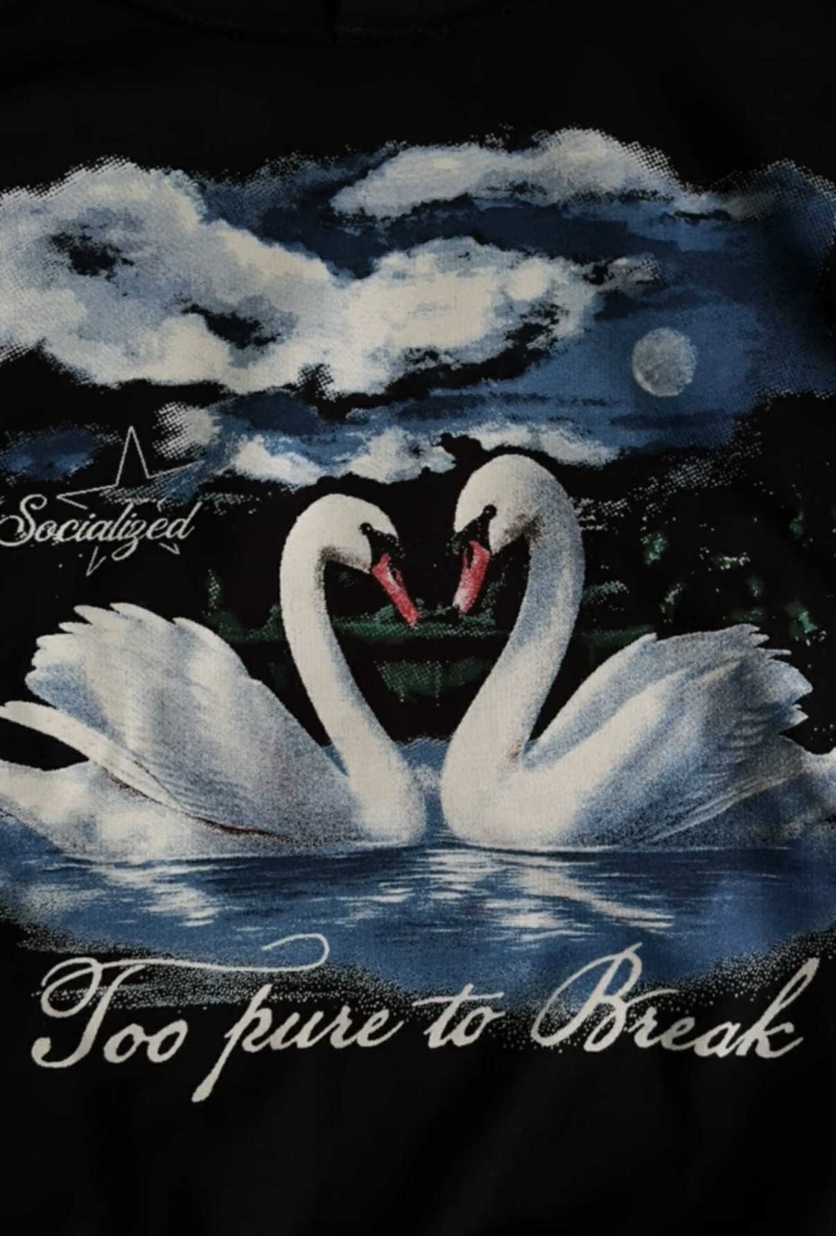 Czarna bluza z sitodrukiem: dwa białe łabędzie tworzą serce na tle nocnego nieba z księżycem. Napis 'Too pure to Break'.
