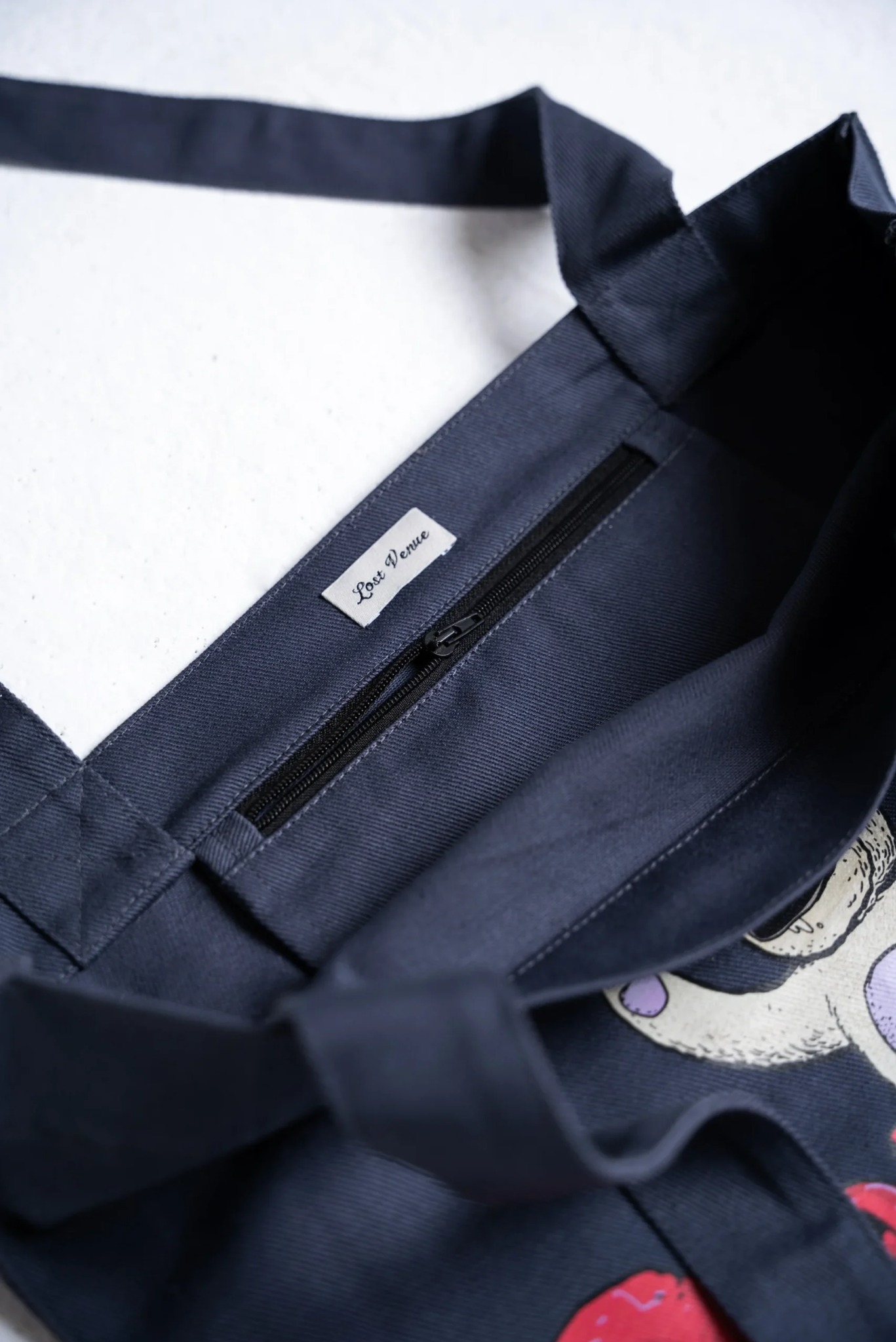 Torba z nadrukiem DTF dla marki odzieżowej z Gdańska. Wnętrze z zapinaną kieszenią i logo. Widoczne detale szycia i grafika.