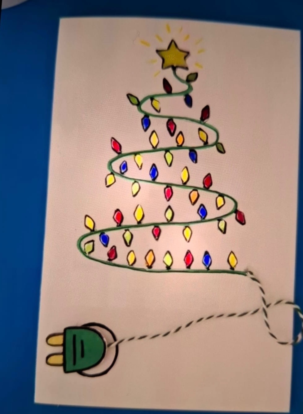 Ręcznie rysowana kartka świąteczna z choinką z lampek, zwieńczoną gwiazdą i zakończoną wtyczką, na białym tle.