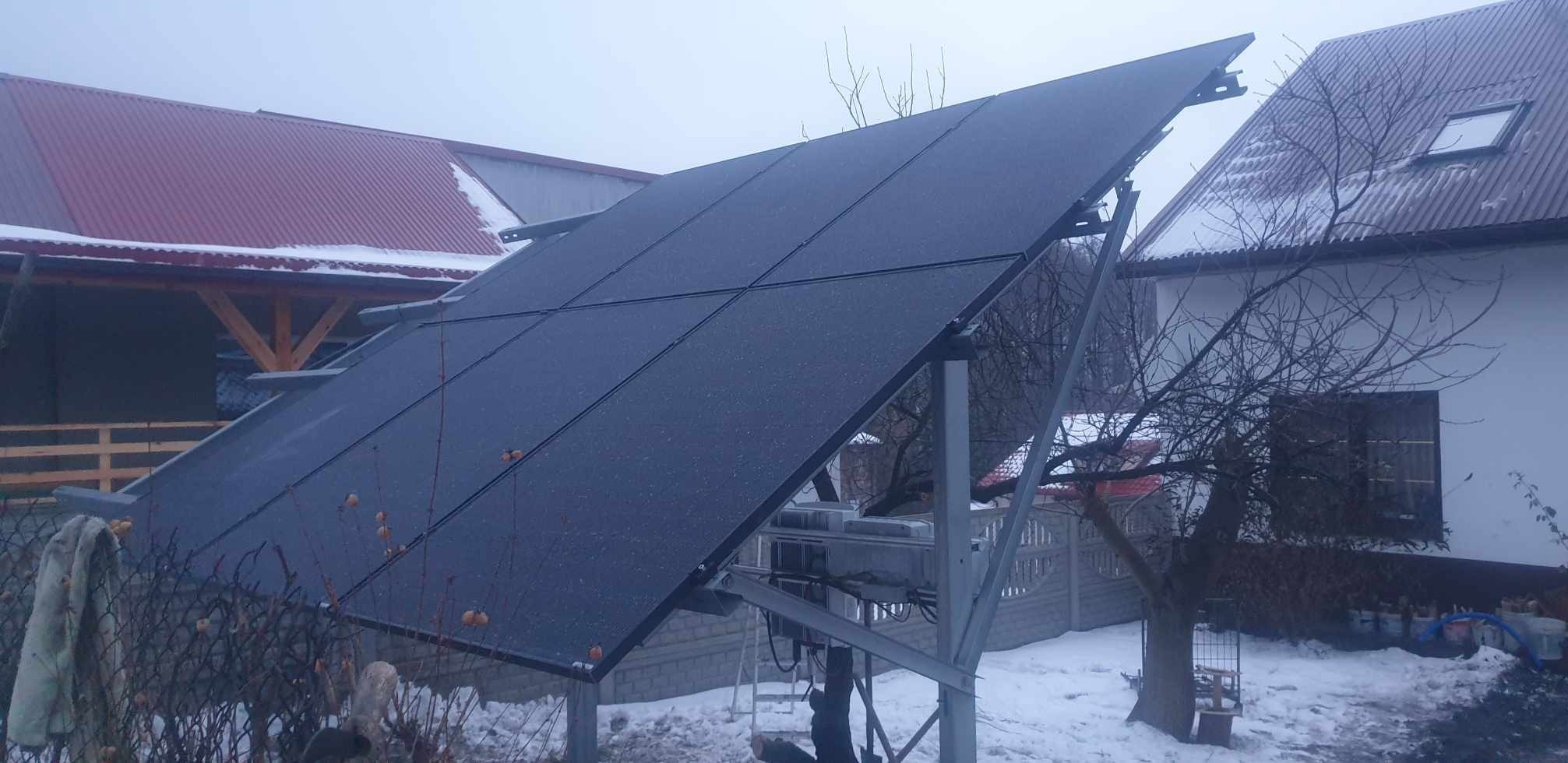 Instalacja fotowoltaiczna na gruncie w zimowej scenerii. Panele ustawione pod kątem, widoczne elementy konstrukcyjne i ośnieżone otoczenie.