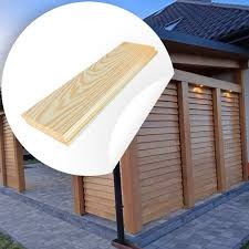 Panel boazeryjny z jasnego drewna na tle fragmentu drewnianej konstrukcji z lamelami i kostki brukowej. Naklejka w rogu dodaje efektu 3D.