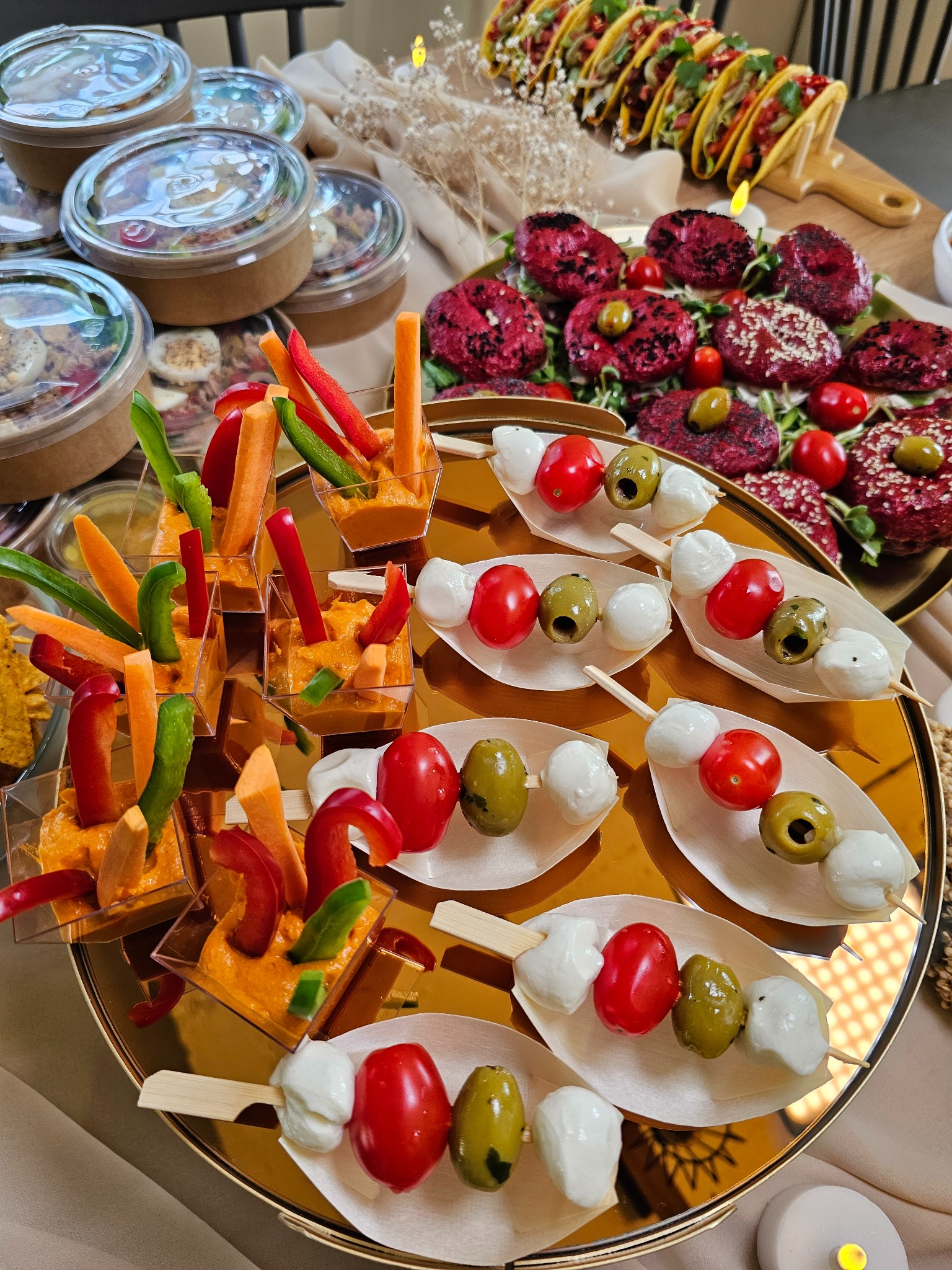 Elegancki catering: warzywne szaszłyki z mini-mozzarellą, kolorowe dipy z warzywami w kubeczkach i burgery z buraka na złotym talerzu.