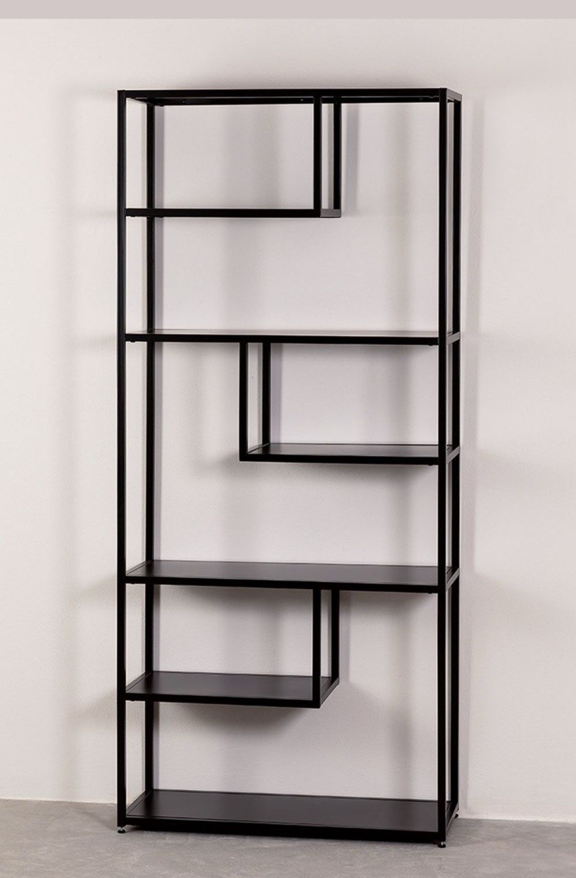 Czarny, metalowy regał o asymetrycznej konstrukcji, na tle białej ściany i szarej podłogi. Minimalistyczny design z otwartymi półkami.