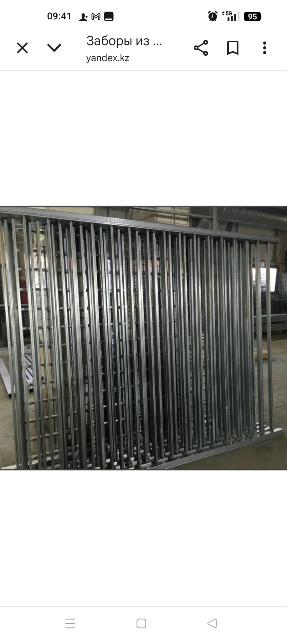 Surowy, metalowy płot z pionowych prętów, spawany w warsztacie. Widoczne ślady obróbki i surowy metal. Konstrukcja przygotowana do dalszej obróbki lub montażu.