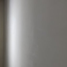 Polwykon - Świeżo pomalowana ściana w odcieniach szarości, oświetlona pionową lampą LED. Widoczne delikatne przejścia tonalne i faktura gładzi. Minimalistyczne ujęcie wnętrza.