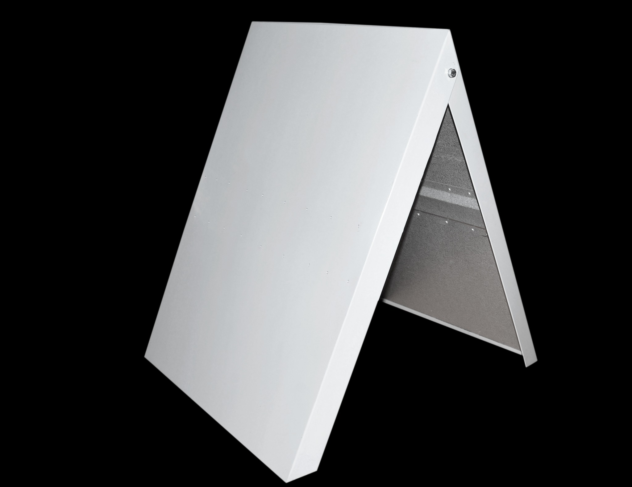 Kątowe ujęcie białej obróbki blacharskiej, widoczna wewnętrzna strona z szarą izolacją, na czarnym tle. Detal łączenia elementów, równomierne oświetlenie.