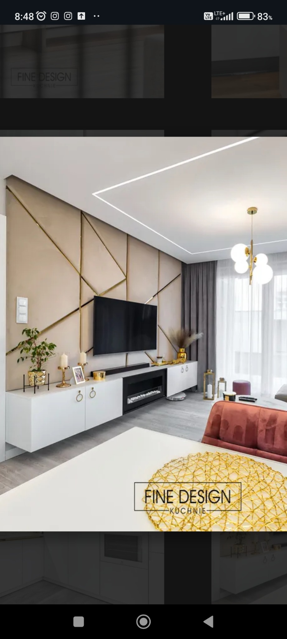 Elegancki salon z beżową ścianą zdobioną złotymi liniami, białymi szafkami RTV z paleniskiem i subtelnym oświetleniem. Nowoczesny design wnętrza.