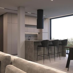 Nycz.design - Nowoczesna aranżacja wnętrza: minimalistyczna kuchnia z wyspą i hokerami, stonowana kolorystyka, duże okno z widokiem na zieleń. Elegancki design.