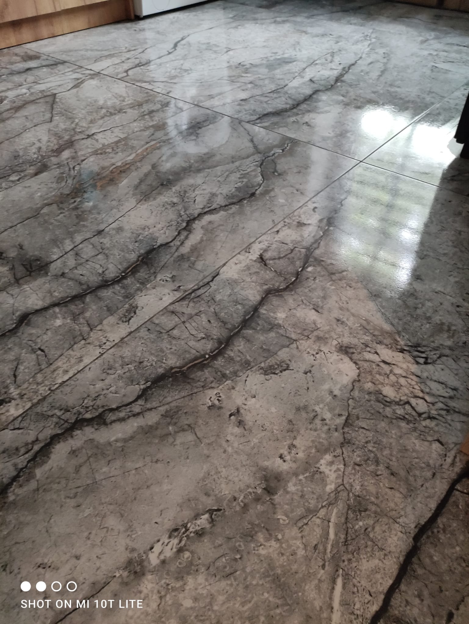 Połyskująca, marmurowa podłoga z płytek w Bytomiu, ułożona z precyzją. Widoczne odbicie światła na gładkiej powierzchni, podkreślające wzór.