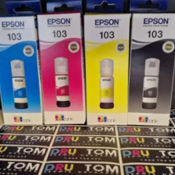 Cztery opakowania tuszy Epson 103 (C, M, Y, BK) na tle arkusza naklejek z logo 'DRU TOM Serwis Drukarek', ukazujące akcesoria do drukarek.