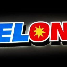 SIGNTRADE POLAND SPÓŁKA Z OGRANICZONĄ ODPOWIEDZIALNOŚCIĄ - Świecący szyld reklamowy ELON z niebiesko-czerwonym logo na czarnym tle. Litery podświetlone, tworzą efekt 3D.