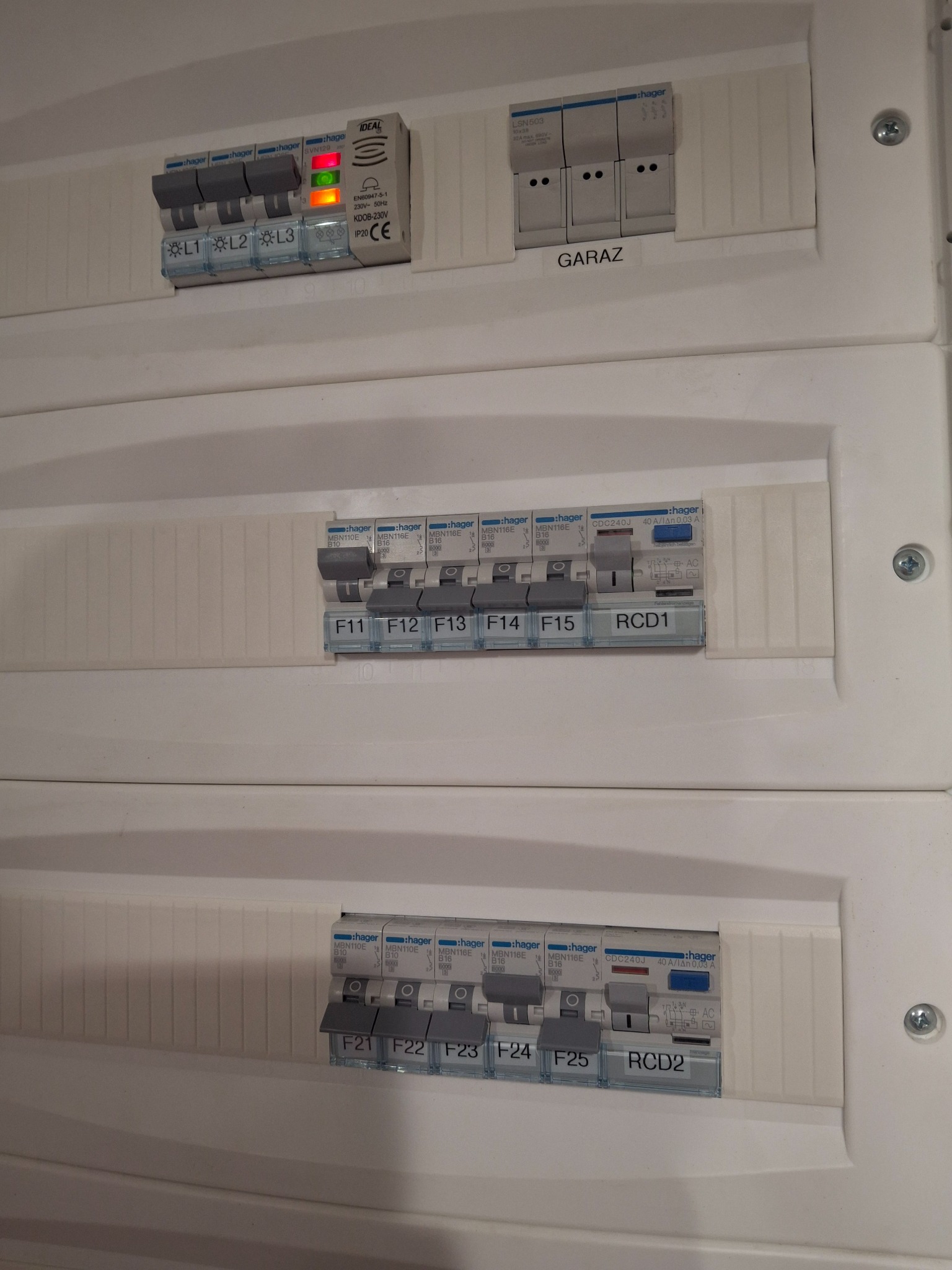 Rozdzielnica elektryczna Hager z bezpiecznikami, w tym RCD1 i RCD2 oraz wyłącznikiem IDEAL. Widoczne oznaczenia L1, L2, L3 i 'Garaż'.