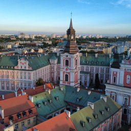 Kamil Cieslak - Panorama Poznania z widokiem na barokowy kościół i zabudowę Starego Miasta, sfotografowana z lotu ptaka w słoneczny dzień.