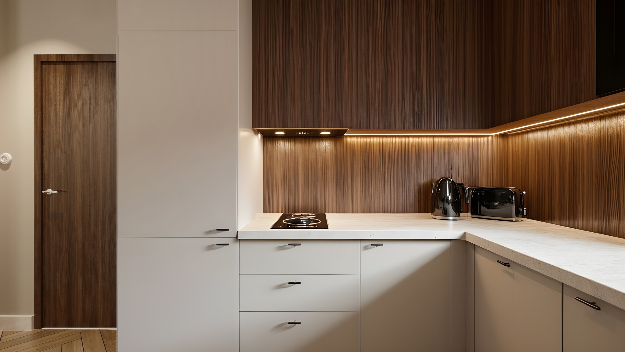 Nowoczesna kuchnia w odcieniach bieli i drewna. Minimalistyczne szafki, płyta indukcyjna, czajnik i toster na blacie. Oświetlenie LED podkreśla drewnianą ścianę.