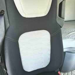 Ekipa czystości - Szczegółowe ujęcie wypranego fotela samochodowego z jasnymi wstawkami i ciemną tapicerką, ukazujące czystość i odświeżony wygląd materiału.