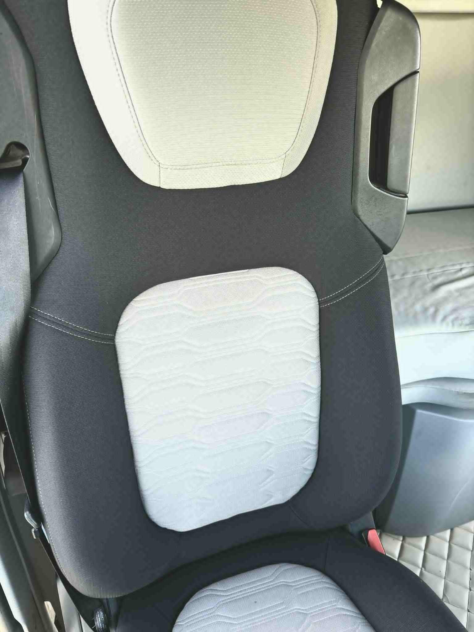 Szczegółowe ujęcie wypranego fotela samochodowego z jasnymi wstawkami i ciemną tapicerką, ukazujące czystość i odświeżony wygląd materiału.