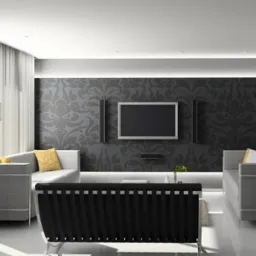 Nowoczesny salon z szarą tapetą w kwiaty, telewizorem, i dwoma szarymi sofami. Oświetlenie LED podkreśla dekoracyjną ścianę. Minimalistyczny design wnętrza.