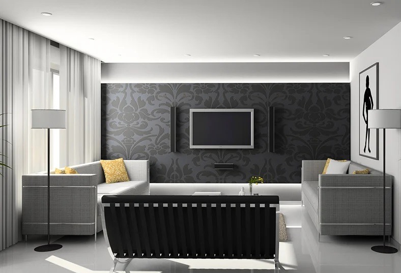 Nowoczesny salon z szarą tapetą w kwiaty, telewizorem, i dwoma szarymi sofami. Oświetlenie LED podkreśla dekoracyjną ścianę. Minimalistyczny design wnętrza.