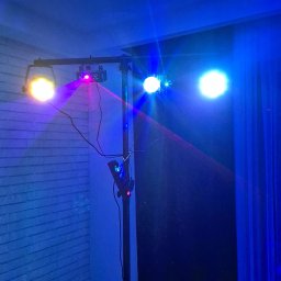 GOLDEN PARTY Łukasz Złoto - Stojak oświetleniowy z reflektorami i laserem, rzucający kolorowe światła na sufit i ścianę z cegły. Efekt dyskotekowy, niebieska poświata.