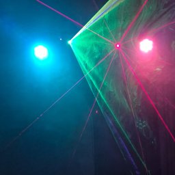 GOLDEN PARTY Łukasz Złoto - Dynamiczne oświetlenie laserowe: zielono-różowe wiązki przecinają ciemność, tworząc futurystyczny efekt wizualny na tle niebieskiego światła.