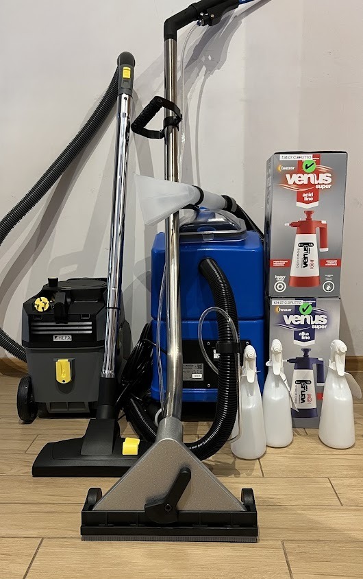 Profesjonalny sprzęt do czyszczenia tapicerki i dywanów: odkurzacz piorący, spryskiwacze i środki czyszczące Venus, gotowe do użycia na drewnianej podłodze.