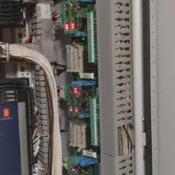 Wnętrze szafy sterowniczej z przewodami, modułami elektronicznymi i listwami DIN. Widoczne oznaczenia TBSS1, TBSS2, TBSS3, TBSS4. Czerwone i zielone diody LED.