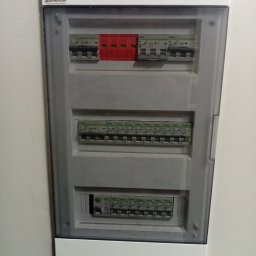 Ireneusz Kwiatkowski - Rozdzielnica elektryczna z zabezpieczeniami przepięciowymi w Kowalach. Widoczne bezpieczniki i ograniczniki przepięć w skrzynce z tworzywa sztucznego.