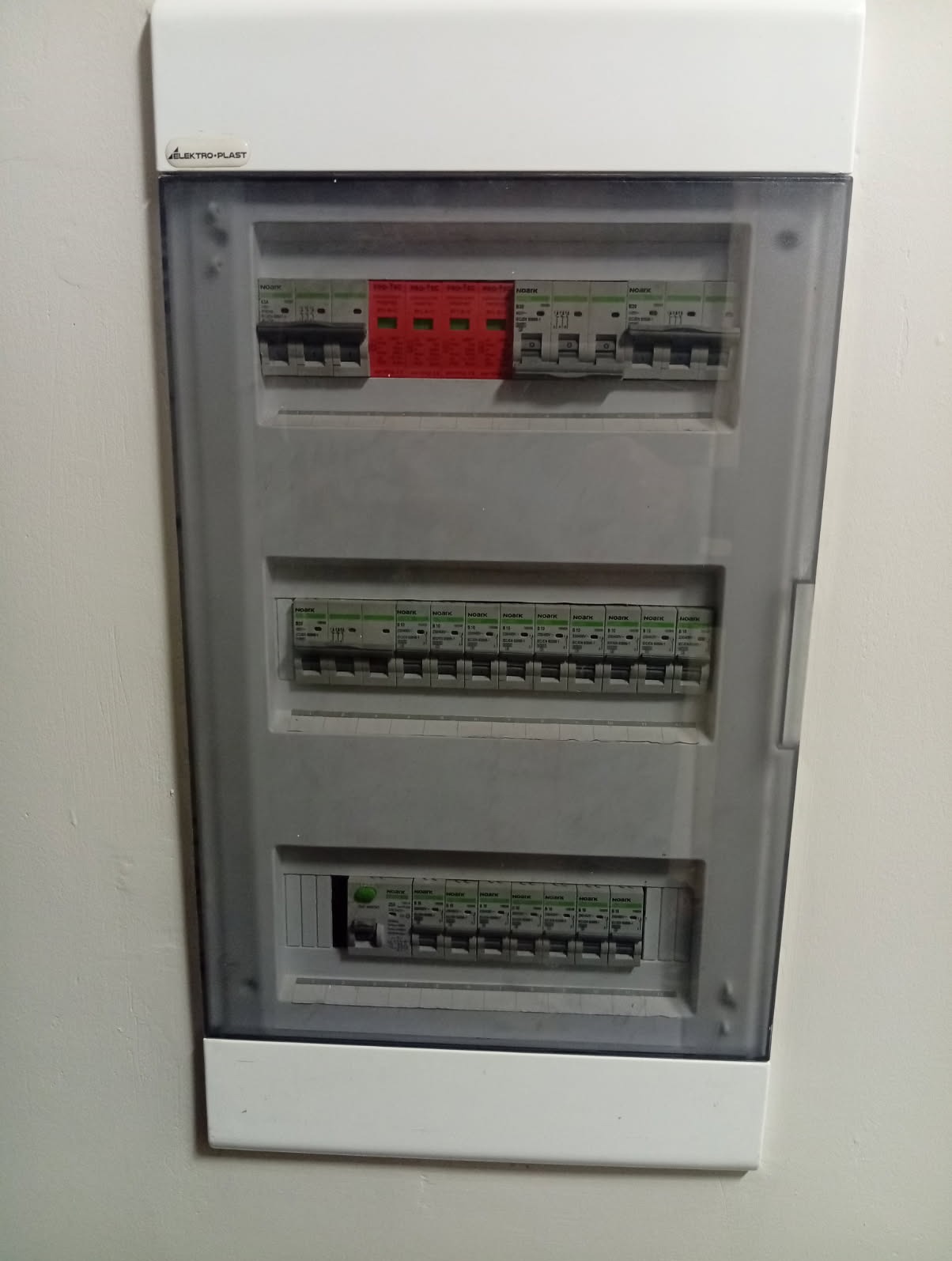 Rozdzielnica elektryczna z zabezpieczeniami przepięciowymi w Kowalach. Widoczne bezpieczniki i ograniczniki przepięć w skrzynce z tworzywa sztucznego.