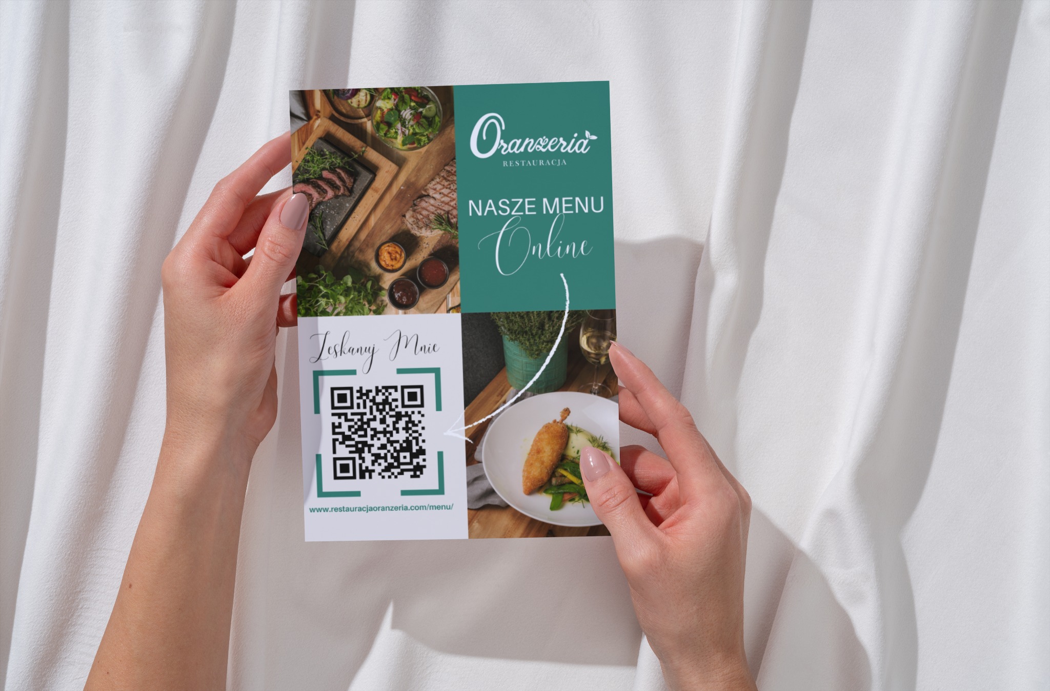 Dłonie trzymają ulotkę restauracji 'Oranżeria' z kodem QR i zdjęciami dań na tle białej tkaniny. Ulotka prezentuje menu online i zachęca do skanowania.