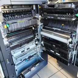 R-TECH ŁUKASZ ROSOWSKI - Otwarta kserokopiarka A3 ukazująca wewnętrzne mechanizmy, rolki i podajniki papieru; widoczne elementy konstrukcyjne i ostrzeżenia na obudowie.