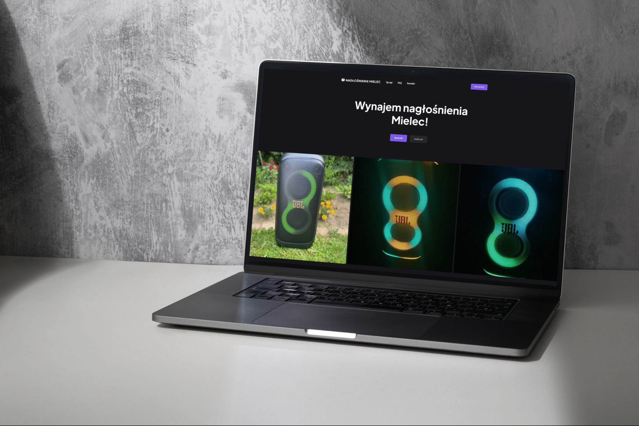 Laptop wyświetla stronę internetową z ofertą nagłośnienia Mielec, prezentującą sprzęt audio JBL na tle minimalistycznego, szarego tła. Widoczne menu strony i przyciski.