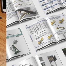 Ilona Mrozowska Grafik Komputerowy - Otwarty katalog z ilustracjami technicznymi i danymi produktów firmy Kolster, widoczny na drewnianym biurku obok telefonu i długopisu. Prezentacja oferty.