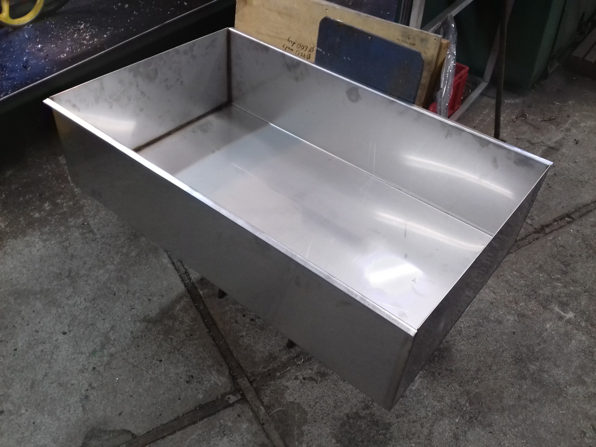 Metalowa wanna ze stali nierdzewnej, spawana z blachy, widoczna w warsztacie. Detal wykonany na zamówienie, szlifowane spawy.