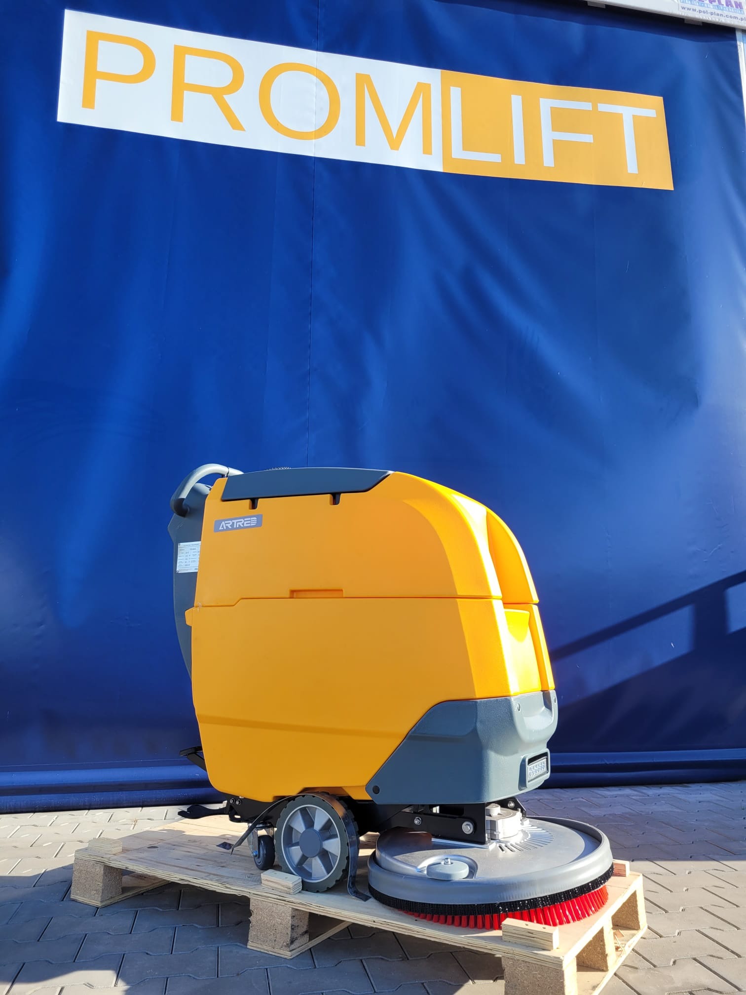Żółto-szara, samojezdna maszyna czyszcząca ARTRES na palecie, z logo PROMLIFT na niebieskim tle. Widoczne szczotki czyszczące i koła. Sprzęt gotowy do transportu.