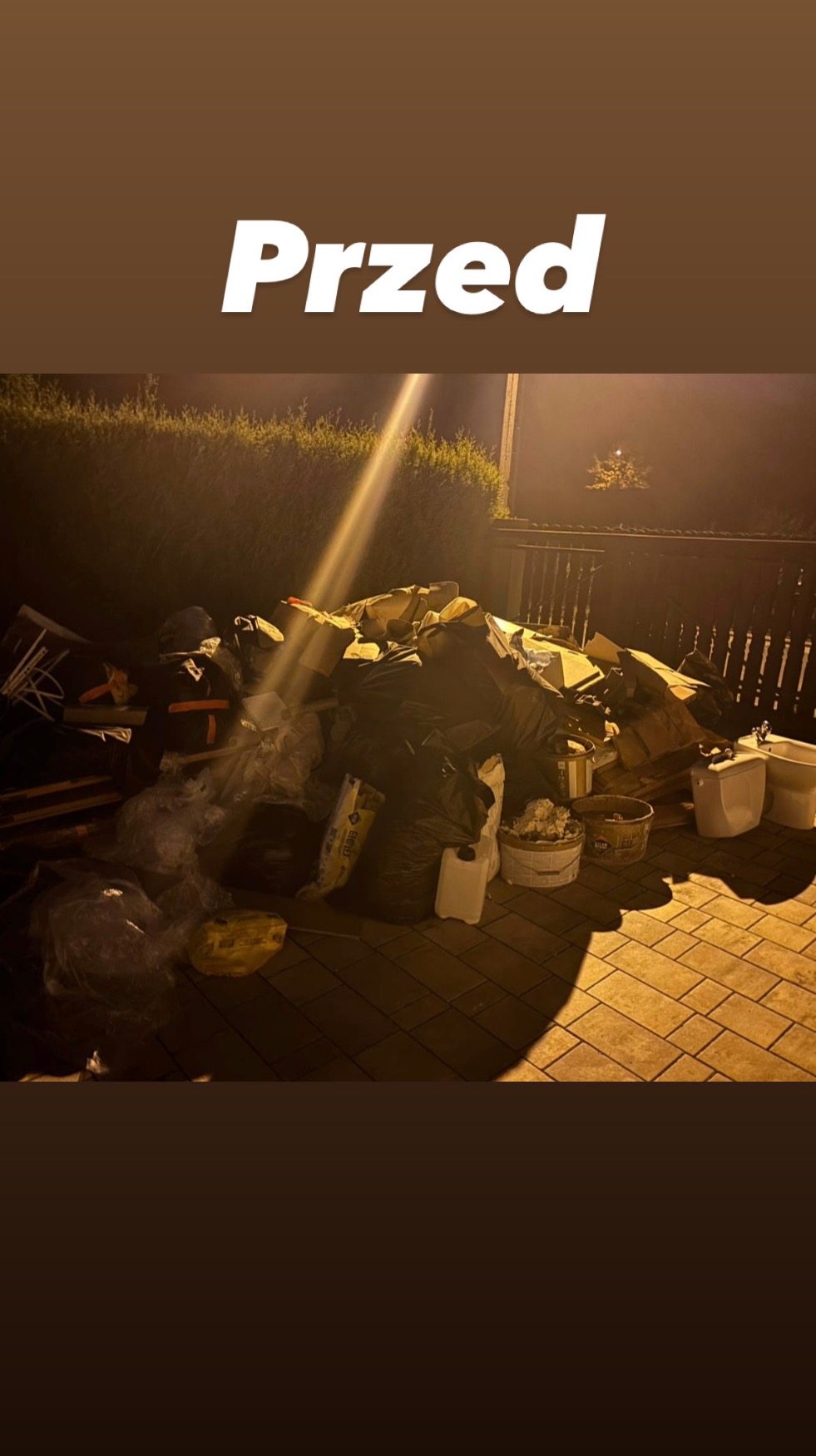 Sterta odpadów budowlanych, kartonów i worków na kostce brukowej, z napisem 'Przed', sugerująca etap przed wywozem gruzu lub opróżnianiem mieszkania.