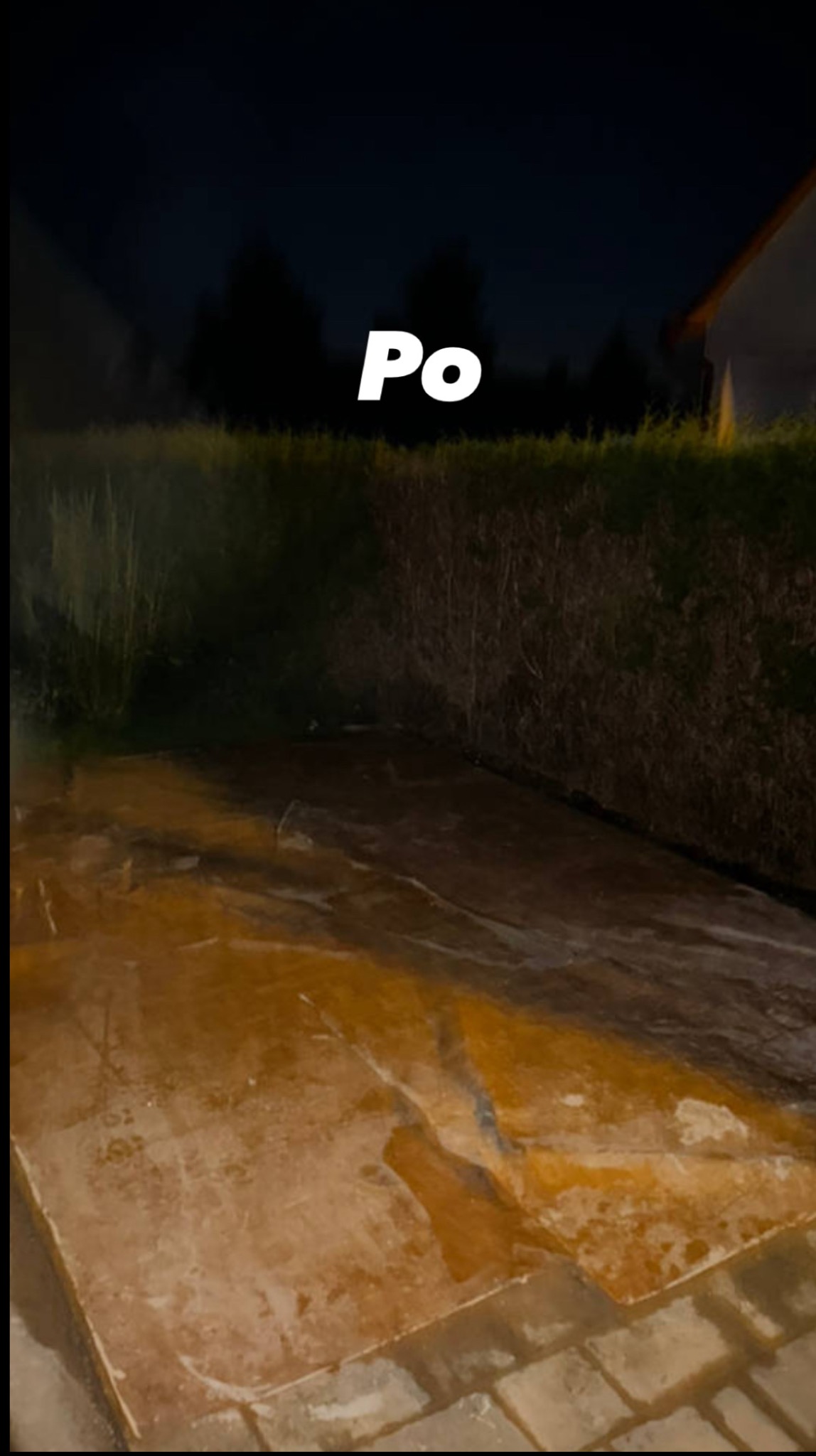 Zdjęcie z zewnątrz, przedstawia efekt 'po' czyszczenia powierzchni, prawdopodobnie po usunięciu zabrudzeń lub gruzu. W tle widoczna zieleń i fragment budynku.