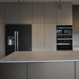 Nowoczesna kuchnia z szarymi frontami, czarną lodówką side-by-side i wyspą z blatem w kolorze piaskowym. Oświetlenie punktowe w suficie.